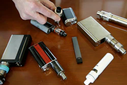 In this April 10, 2018 file photo, a high school principal displays vaping devices that were confiscated from students in such places as restrooms or hallways at the school in Massachusetts.