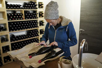 In this photo taken on Wednesday, Nov. 13, winemaker Claire Chasselay lays the labels on bottles of wine in her cellar in Chatillon d'Azergues, in the Beaujolais region, eastern France.