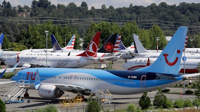 This Aug. 15, 2019 file photo shows dozens of grounded Boeing 737 MAX airplanes crowd a parking area adjacent to Boeing Field in Seattle.