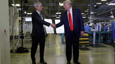 Apple CEO Tim Cook and President Donald Trump shake hands during a tour of an Apple manufacturing plant on Wednesday, Nov. 20 in Austin.