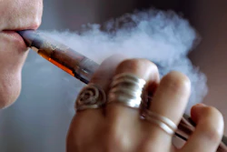 In this Oct. 4 file photo, a woman using an electronic cigarette exhales a puff of smoke in Mayfield Heights, OH.