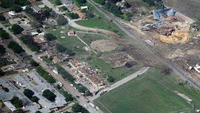 This April 18, 2013 aerial file photo shows the remains of a nursing home, left, apartment complex, center and fertilizer plant, right, destroyed by an explosion at a fertilizer plant in West, Texas. The Trump administration is scaling back chemical plant safety measures that were put in place after the Texas fertilizer plant explosion in 2013 that killed 15 people.