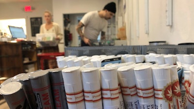 In this Sept. 20, 2019 file photo, employees at the marijuana retailer Bridge City Collective in Portland, OR, can be seen setting up the store for the day behind a row of marijuana products for sale there.