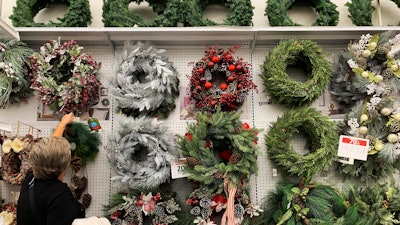 In this Nov. 9 file photo, a woman looks through holiday wreaths on sale at a retail store during in Pembroke Pines, FL.