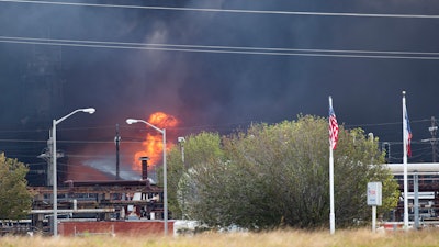 Smoke and fire are visible from the TPC Group Port Neches Operations explosion on Wednesday, Nov. 27, 2019, in Port Neches, Texas. Three workers were injured early Wednesday in a massive explosion at the Texas chemical plant that also blew out the windows and doors of nearby homes.