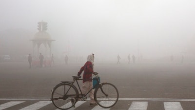 This Jan. 18, 2019 file photo shows a cyclist amidst morning smog in New Delhi, India. Beth Gardiner's new book 'Choked' documents how air pollution is responsible for seven million premature deaths around the world. Inger Andersen, head of the U.N. Environment Program, says the world needs 'quick wins to reduce emissions as much as possible in 2020.' Ahead of a global climate summit in Madrid next week, her agency published a report Tuesday showing the amount of planet-heating gases released into the atmosphere hitting a new high last year.