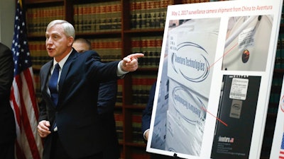 U.S. Attorney Richard P. Donoghue announces charges against Aventura Technologies, Thursday, Nov. 7, 2019, in the Brooklyn borough of New York. The New York company has been charged with illegally importing and selling Chinese-made surveillance and security equipment to U.S. government agencies and private customers.