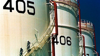 In this Monday, September 25, 2000 file photo, two workers climb down from one of the tanks in an oil tank-farm in Jebel Ali, 25 miles (40 kms.) south of Dubai in the United Arab Emirates. The United Arab Emirates now says it is home to the world's sixth-largest crude oil reserves, surpassing fellow Gulf Arab nation Kuwait.