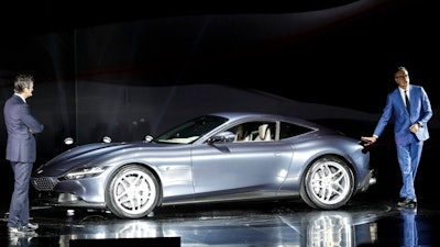 Ferrari Chief Marketing and Commercial Officer, Enrico Galliera, left, and Ferrari design senior vice President, Flavio Manzoni, present the new Ferrari Roma car, in Rome, Thursday, Nov. 14, 2019. Ferrari unveils a new sports coupe aimed at enticing entry-level buyers and competing with the Porsche 911, part of a complete refresh of its model lineup by 2022.