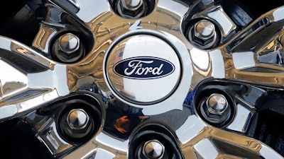 In this Feb. 14, 2019, file photo a wheel on a 2019 Ford Expedition 4x4 is displayed at the 2019 Pittsburgh International Auto Show in Pittsburgh. Members of the United Auto Workers union at Ford Motor Co. have voted to approve a new contract with the company. The union says in a statement Friday, Nov. 15, 2019, that 56.3% of workers who voted were in favor of the deal.