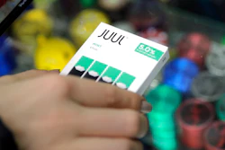In this Dec. 20, 2018, file photo a woman buys refills for her Juul at a smoke shop in New York. The e-cigarette maker Juul Labs said Thursday, Nov. 7, 2019, that it will halt sales of its best-selling mint-flavored vaping pods.