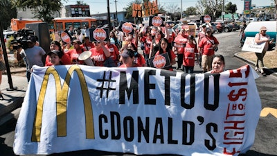 In this Sept. 18, 2018, file photo, McDonald's workers carry a banner and march towards a McDonalds in south Los Angeles. Roughly a third of American workers say they've changed how they act at work in the past year, as the #MeToo movement has focused the nation's attention on sexual misconduct. That's according to a new poll of full- or part-time workers released Tuesday by The Associated Press-NORC Center for Public Affairs Research and the software company SAP.