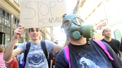Protesters hold signs critical of agro-giant Monsanto.