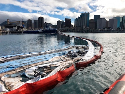 In this photo provided by the U.S. Coast Guard, their crews and other local agencies respond to an oil discharge from vessel Kamokuiki at Pier 19 in Honolulu, Thursday, Nov. 7, 2019. Two response vessels arrived on scene and deployed 1,600 feet of hard boom surrounding the 25 bales of absorbent material.