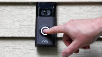 In this July 16, 2019, file photo, Ernie Field pushes the doorbell on his Ring doorbell camera at his home in Wolcott, Conn. Amazon says it has considered adding facial recognition technology to its Ring doorbell cameras. The company said in a letter released Tuesday, Nov. 19 by U.S. Sen. Ed Markey that facial recognition is a “contemplated, but unreleased feature” of its home security cameras. The Massachusetts Democrat wrote to Amazon CEO Jeff Bezos in September raising privacy and civil liberty concerns about Ring’s video-sharing partnerships with hundreds of police departments around the country.