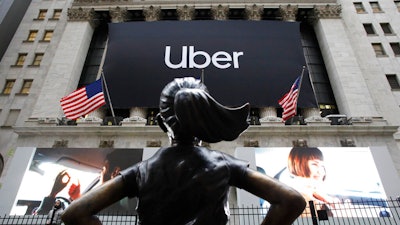 In this May 10, 2019, file photo the statue of Fearless Girl stands in front of the New York Stock Exchange before Uber holds its initial public offering. Uber reports financial results Monday, Nov. 4.