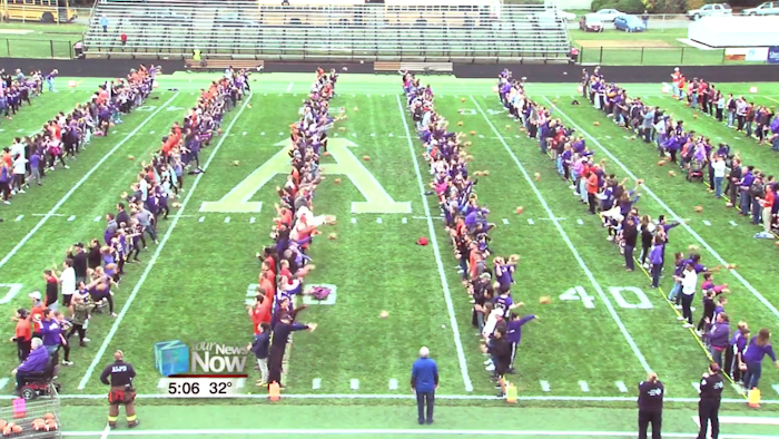 This still image taken from video provided by WLIO-TV shows 950 people throwing footballs at the same time on Oct. 25, 2019 at the Ada War Memorial Stadium football field in Ada, Ohio. The Ohio town long associated with the manufacturing of footballs has set a Guinness World Record for the most footballs thrown at once. The record-keeping organization certified the record.