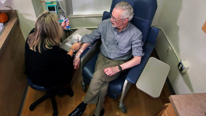 Charles Flagg, who is stricken with Alzheimer's disease, sits for an infusion while participating in a study on the drug Aducanumab at Butler Hospital in Providence, R.I.