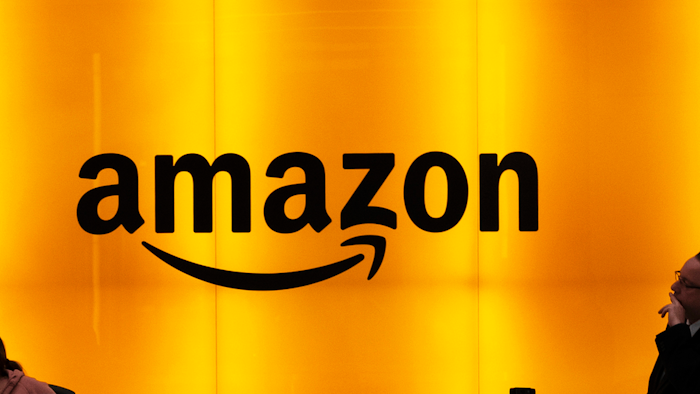 In this Feb. 14, 2019, file photo people stand in the lobby for Amazon offices in New York. Amazon says President Donald Trump's “improper pressure' and behind-the-scenes attacks harmed its chances of winning a $10 billion Pentagon contract. Amazon argues in a lawsuit unsealed Monday, Dec. 9, that the decision should be revisited because of “substantial and pervasive errors' and Trump's interference.