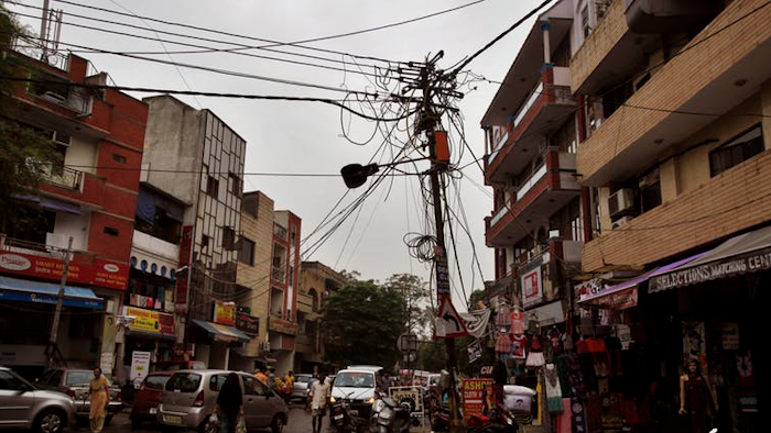 A power pole in New Delhi, India. Reconfiguring wiring on the local electric grid is one way to reduce loss through inefficient transmission of power. Theft of power is a large contribute to energy loss.