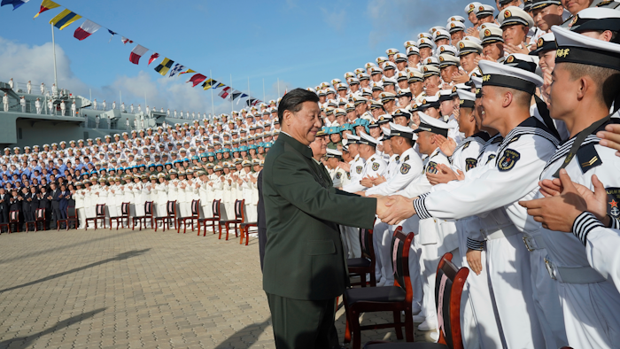 In this photo provided by China's Xinhua News Agency, Chinese President Xi Jinping, center, meets with representatives of the aircraft carrier unit and the manufacturer at a naval port in Sanya, south China's Hainan Province, Tuesday, Dec. 17, 2019. President Xi attended the commissioning of China’s first entirely home-built aircraft carrier, underscoring the country's rise as a regional naval power at a time of tensions with the U.S. and others over trade, Taiwan and the South China Sea.
