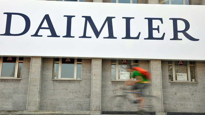 In this April 8, 2009 file photo, a cyclist passes a logo of German car company Daimler in Berlin. German automaker Daimler said Friday, Nov. 29, 2019 that it plans to cut at least 10,000 jobs worldwide by the end of 2022. The company had said Nov. 14 that it plans to slash costs by 1.4 billion euros ($1.54 billion) by cutting every tenth managerial position and through other measures, but didn’t give details.