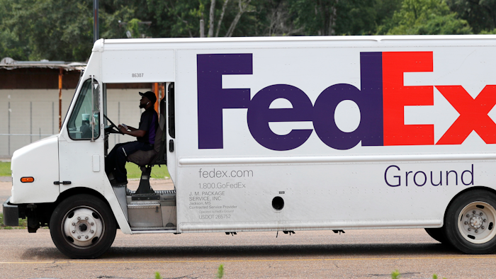 In this June 25, 2019, file photo, a FedEx Ground package van pulls into a business driveway in this north Jackson, Miss., facility. Amazon is banning its third-party merchants from using FedEx's ground service to deliver to Prime members, suggesting that it thinks the service is too slow to get packages to their destinations in time for Christmas.