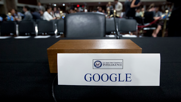 In this Sept. 5, 2018, file photo, an empty chair reserved for Google's parent Alphabet, which refused to send its top executive, is seen before the Senate Intelligence Committee hearing on Capitol Hill in Washington. The co-founders of Google are stepping down as executives of its parent company, Alphabet.