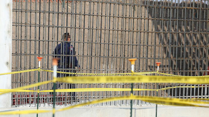 A McAllen K-9 police officer walks past rebar that will make up the border wall before DHS Acting Homeland Secretary Chad Wolf tours and speaks to the local media at the border wall under construction on Thursday, Nov. 21, 2019, south of Donna, Texas.