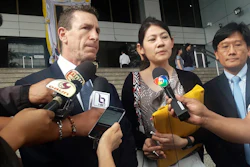 Gerald Margolis, center left, branch manager of Philip Morris in Thailand, talks to reporters at Criminal Court in Bangkok, Thailand on Friday, Nov. 29.