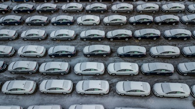 In this Dec. 5, 2018 file photo, hundreds of Chevrolet Cruze cars sit in a parking lot at General Motors' assembly plant in Lordstown, Ohio. The long-struggling Rust Belt community of Youngstown, Ohio, which was stung by the loss of the massive General Motors Lordstown plant this year, wants to become a research and production hub for electric vehicles.. But Youngstown faces competition from places like Detroit and China that are taking big roles in developing electric vehicles.