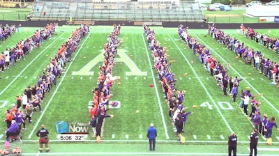 This still image taken from video provided by WLIO-TV shows 950 people throwing footballs at the same time on Oct. 25, 2019 at the Ada War Memorial Stadium football field in Ada, Ohio. The Ohio town long associated with the manufacturing of footballs has set a Guinness World Record for the most footballs thrown at once. The record-keeping organization certified the record.