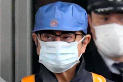 In this March 6, 2019, file photo, a masked man, front with blue cap, believed to be former Nissan Chairman Carlos Ghosn, leaves Tokyo's Detention Center in Tokyo. Former Nissan chairman Carlos Ghosn, who is awaiting trial in Japan on charges of financial misconduct, has arrived in Beirut, a close friend said Monday, Dec. 31, 2019. He apparently jumped bail. It was not clear how Ghosn, who is of Lebanese origin and holds French and Lebanese passports, left Japan where he was under surveillance and is expected to face trial in April 2020.