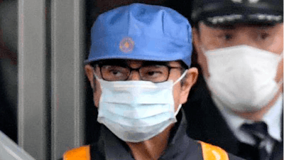 In this March 6, 2019, file photo, a masked man, front with blue cap, believed to be former Nissan Chairman Carlos Ghosn, leaves Tokyo's Detention Center in Tokyo. Former Nissan chairman Carlos Ghosn, who is awaiting trial in Japan on charges of financial misconduct, has arrived in Beirut, a close friend said Monday, Dec. 31, 2019. He apparently jumped bail. It was not clear how Ghosn, who is of Lebanese origin and holds French and Lebanese passports, left Japan where he was under surveillance and is expected to face trial in April 2020.