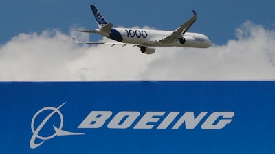 In this June 17, 2019, file photo, an Airbus A 350 - 1000 performs his demonstration flight at Paris Air Show in Le Bourget, east of Paris, France. Boeing's grounded 737 Max got a boost from two orders in November, but the American aircraft company continues to trail Europe's Airbus in both orders and deliveries of airline planes. Boeing disclosed Tuesday, Dec. 10, that it received 11 net orders in November, 63 new orders but 52 cancellations.