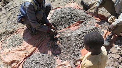 François and his 13-year-old son, Charles, sort stones before taking them to a nearby trading house that buys the ore, Democratic Republic of Congo, 2016.