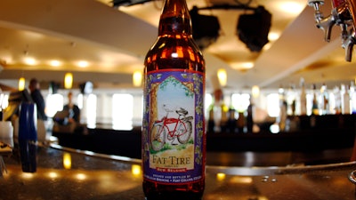 In this April 13, 2008, file photo, a bottle of Fat Tire Amber Ale, made by New Belgium Brewing Co., sits on the bar in the club level of the Pepsi Center in Denver. Employees approved the sale of one of the largest U.S. craft breweries to a subsidiary of Japanese beverage company Kirin in a vote that ended Tuesday, Dec. 17, 2019, clearing the way for the sale to close by the end of the year. New Belgium Brewing Co. declined to release the number of employees who voted in favor of the sale to Lion Little World Beverages of Australia or a breakdown of how they voted, the Coloradoan reported.
