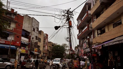 A power pole in New Delhi, India. Reconfiguring wiring on the local electric grid is one way to reduce loss through inefficient transmission of power. Theft of power is a large contribute to energy loss.