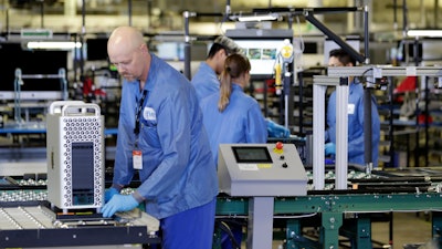 In this Nov. 20, 2019, file photo workers assemble Apple products at an Apple manufacturing plant in Austin, Texas. On Tuesday, Dec. 17, the Federal Reserve reports on U.S. industrial production for November.