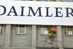 In this April 8, 2009 file photo, a cyclist passes a logo of German car company Daimler in Berlin. German automaker Daimler said Friday, Nov. 29, 2019 that it plans to cut at least 10,000 jobs worldwide by the end of 2022. The company had said Nov. 14 that it plans to slash costs by 1.4 billion euros ($1.54 billion) by cutting every tenth managerial position and through other measures, but didn’t give details.