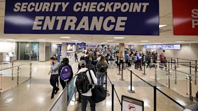 In this Wednesday, Nov. 27, 2019 file photo, Travelers walk through a security checkpoint in Terminal 2 at Salt Lake City International Airport in Salt Lake City. The Homeland Security Department is backing away from requiring U.S. citizens to submit to facial-recognition technology when they leave or enter the country. The department said Thursday, Dec. 5, 2019 that it has no plans to expand facial recognition to U.S. citizens. A spokesman said DHS will delete the idea from its regulatory agenda, where privacy advocates spotted it this week.