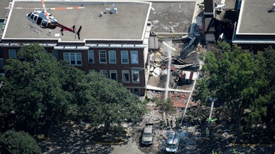 In this Aug. 2, 2017 file photo, emergency workers respond to an explosion at Minnehaha Academy in Minneapolis. Federal investigators say a pipefitting crew lacked proper training when they moved a gas meter just before a Minneapolis school explosion that killed two people in 2017. The National Transportation Safety Board released its report Monday, Dec. 2, 2019 on the explosion at Minnehaha Academy.