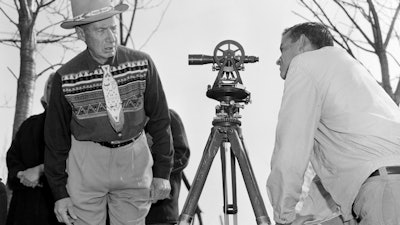 In this April 18, 1958, file photo, Philip N. Brooks, right, a New York State surveyor, takes a look through his transit on the Tuscarora Indian Reservation near Niagara Falls, N.Y., while Tuscarora Chief Elton Black Cloud Greene watches.