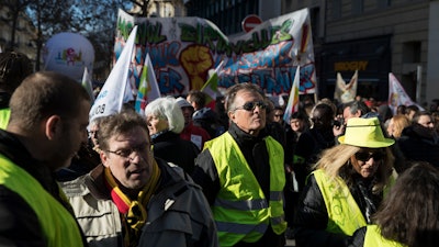 Yellow vest protesters gather for a march during a mass strike in Marseille, southern France, Tuesday, Dec. 10, 2019. French airport employees, teachers and other workers joined nationwide strikes Tuesday as unions cranked up pressure on the government to scrap upcoming changes to the country's national retirement system.