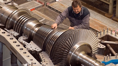 In this 2009 file photo, an employee of MAN Turbo company works on compressors and turbines at the factory in Oberhausen, western Germany.