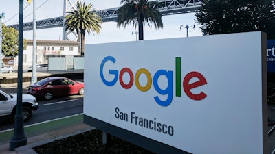 In this Oct. 31, 2018, file photo shows signage outside the offices of Google in San Francisco with the San Francisco-Oakland Bay Bridge in the background. Four workers fired from Google in November 2019 are planning to file charges against the company with a federal agency. They are claiming the company unfairly retaliated against them for organizing workers around social causes.