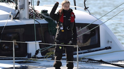 Climate activist Greta Thunberg waves as she arrives in Lisbon aboard the sailboat La Vagabonde Tuesday, Dec 3, 2019. Thunberg has arrived by catamaran in the port of Lisbon after a three-week voyage across the Atlantic Ocean from the United States. The Swedish teen sailed to the Portuguese capital before heading to neighboring Spain to attend the U.N. Climate Change Conference taking place in Madrid.