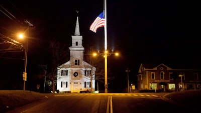 In this Dec. 15, 2012 file photo, a U.S. flag flies at half-staff on Main Street in Newtown, Conn., in honor of the 26 students and staff killed in a shooting at the Sandy Hook Elementary school. Vigils and church services were held Saturday, Dec. 14, 2019, in Newtown to mark the seventh anniversary of the Dec. 14, 2012, shooting and remember victims of other gun violence.