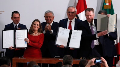 Mexico's Treasury Secretary Arturo Herrera, left, Deputy Prime Minister of Canada Chrystia Freeland, second left, Mexico's President Andres Manuel Lopez Obrador, center, Mexico's top trade negotiator Jesus Seade, second right, and U.S. Trade Representative Robert Lighthizer, hold the documents after signing an update to the North American Free Trade Agreement, at the national palace in Mexico City, Tuesday, Dec. 10. 2019.