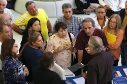 In this Sept. 18, 2019, file photo people inquire about temporary positions available for the 2020 Census during a job fair designed for people fifty years or older in Miami. On Friday, Dec. 6, the U.S. government issues the November jobs report.